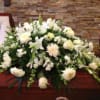 White funeral casket spray with lilies and chrysanthemums