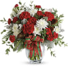 Red and white floral arrangement in a glass vase with a plaid ribbon