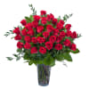 Tall bouquet of red roses in a clear glass vase
