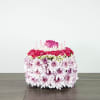 Round floral cake with pink roses, carnations, and candles