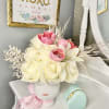 Pink and white flower arrangement in a face-shaped vase with a ribbon