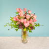 Pink roses and anthuriums arranged in a clear glass vase