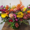 Mixed bouquet with roses, calla lilies, and bright orange and purple flowers in a vase