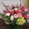 Mixed pink and white floral arrangement in a green vase