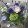 Bouquet of purple, blue, and blush flowers in a glass vase