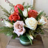 Mixed roses and white tulips in a green glass vase