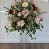 Mixed pink and red roses in a clear pedestal vase