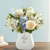 White and blue floral arrangement in a white vase with a cross emblem