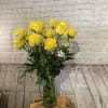 Yellow roses in a clear glass vase with white filler flowers