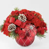 Red roses and carnations arranged with pinecones in a red ornament vase