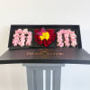 Heart-shaped rose box with pink and red roses and a yellow flower