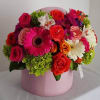 Mixed bouquet of roses and gerbera daisies in a pink hat box