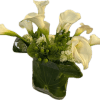 White calla lilies arranged in a glass vase with green accents