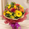 Mixed bouquet of yellow, orange, and pink flowers in a wrapped basket