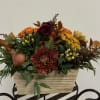 Autumn floral arrangement in a wood-look rectangular container with orange and burgundy blooms