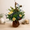Mixed floral arrangement in a brown handled container with a fish accent