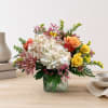Mixed bouquet in a square glass vase with hydrangeas and roses