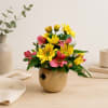 Yellow and pink flowers arranged in a small wooden bear-shaped vase