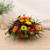 Mixed orange, yellow, and purple flowers in a low bowl arrangement