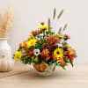Autumn floral arrangement in a painted ceramic vase with yellow and orange blooms