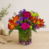 Colorful mixed bouquet in a clear glass vase with decorative stones