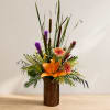 Tall tropical flower arrangement in a bark-covered vase with orange and purple blooms