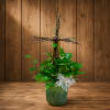 Potted green plant arrangement with a white ribbon and twig cross topper