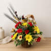 Basket arrangement with red and yellow flowers and a decorative bird topper