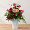 Mixed bouquet in a white metal bucket with pink and burgundy flowers