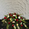 Red and white floral casket spray with roses and daisies