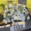 White roses and chrysanthemums with blue flowers in a cemetery vase arrangement