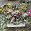 Succulent and magenta flower arrangement in a painted wooden box