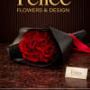 Bouquet of red roses wrapped in black paper with a red ribbon