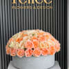 Large peach and cream rose arrangement in a round gray container