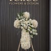 White floral standing cross on an easel