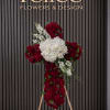 Red and white floral cross on a wooden stand
