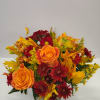Orange and red flower arrangement in a clear glass vase