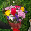 Mixed bouquet of roses and chrysanthemums wrapped in red cellophane with a bow