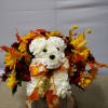 White teddy bear arrangement with autumn flowers and a leaf ribbon in a wooden base