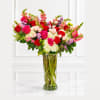 Mixed bouquet of red and pink roses in a tall glass vase