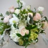 Pastel roses and white blooms arranged in a low vase