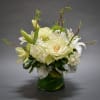 White floral arrangement in a green glass vase