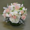 Round bouquet of pink roses and white flowers in a green vase