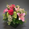 Pink and red mixed flower bouquet in a black vase