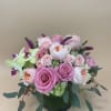 Pink and white rose arrangement in a dark vase