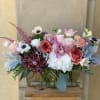 Mixed bouquet of pink, white, and purple flowers in a glass vase