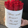 Red roses in a white round box with gold text