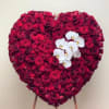 Heart-shaped arrangement of red roses with white orchids