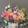 Mixed bouquet with pink tulips, roses, orchids, and anthurium in a white hatbox