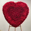 Heart-shaped arrangement of red roses on an easel